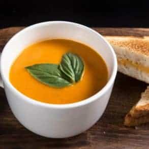 Make this Delicious Creamy Comfort: Instant Pot Tomato Soup Recipe (Pressure Cooker Tomato Soup)! This homemade tomato basil soup from scratch (with vegan option) is healthy, super easy to make, and freezer-friendly. Perfect dip for the toasted golden grilled cheese.